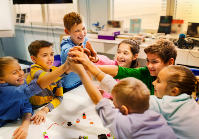 Criança dando as mãos em sala de aula