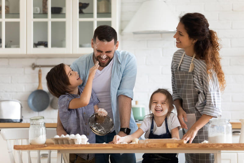 pai, mãe e filhos cozinhando