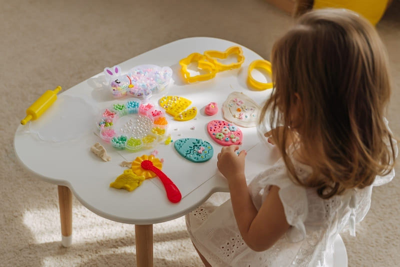 Menina decorando enfeites de ovos de Páscoa