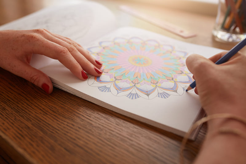 Muulher pintando mandala com lápis de cor