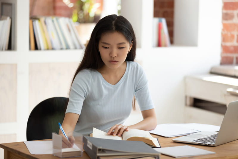 Adolescente estudando na biblioteca