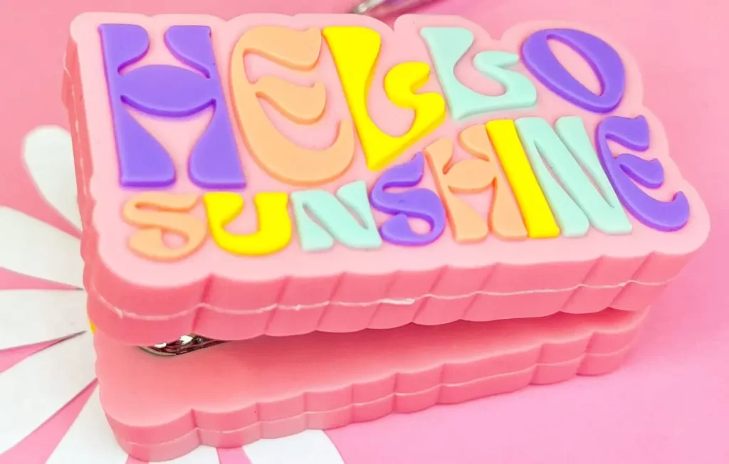 Item da linha Holic Dopamina da Tris com letreiro "hello sunshine" em fundo rosa
