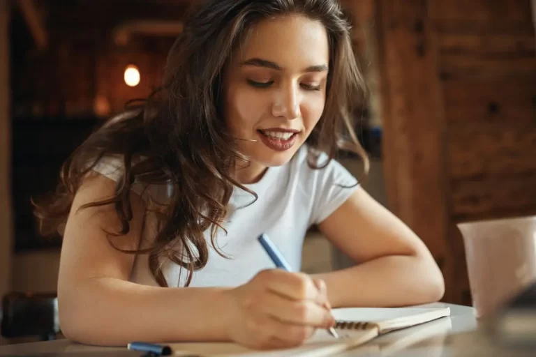 Jovem escrevendo em caderno