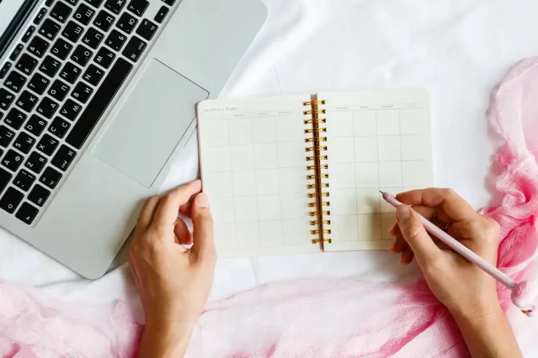 Agenda planner sem data mensal ao lado de laptop