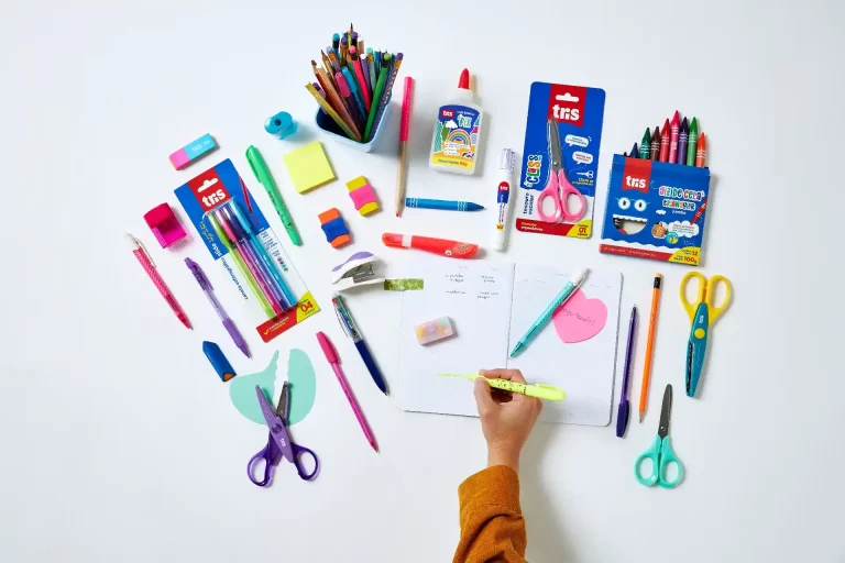 Mesa organizada com materiais escolares como canetas, lápis coloridos, cadernos e tesouras, ideal para estudo e trabalho criativo, uma dica Tris de onde comprar material escolar