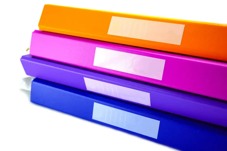 Imagem colorida de pastas de organização em tons vibrantes, incluindo laranja, rosa, roxo e azul, ideais para escritório ou escola.